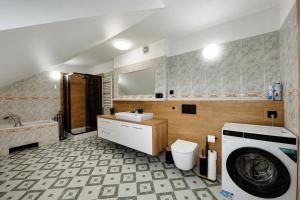 a bathroom with a sink and a washing machine at Apartament pod gruszą in Legbąd