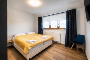 a bedroom with a bed and a blue chair at Apartament pod gruszą in Legbąd