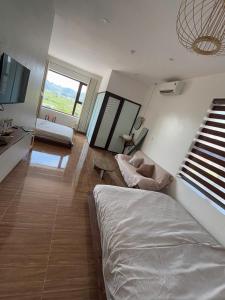 a living room with a bed and a couch at Lơ Mơ House in Làng Môn