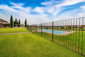 a fence with a pool in a yard at Swallows Nest Haven in Boksburg