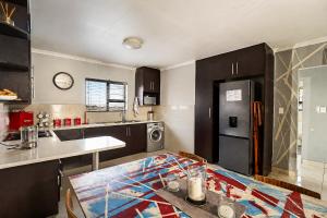 a kitchen with a table and a refrigerator at Swallows Nest Haven in Boksburg