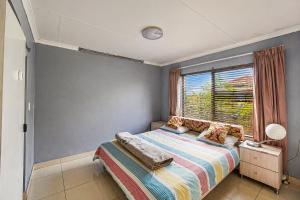 a small bedroom with a bed and a window at Swallows Nest Haven in Boksburg +12 photos