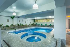 a large swimming pool with blue water in a building at Yahweh's Spring Retreat and Resort in Calamba