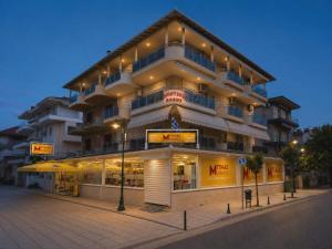 a large building with a store in front of it at Dionysos Rooms in Olympic Beach