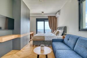 a hotel room with a bed and a blue couch at Quercus Villa 2 in Blizikuće +135 photos