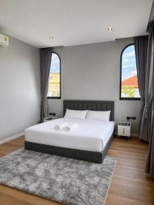 a bedroom with a large white bed and two windows at An An Pool Villa in Nong Prue +40 photos