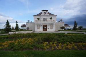 a white house with a balcony on top of it at Winery La Gora in Irig