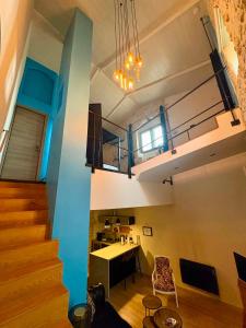 a room with a staircase and a blue wall at Logis de Cupidon in Châteauneuf-du-Rhône
