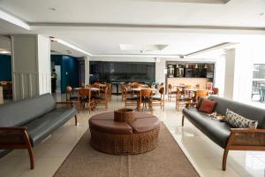 a living room with couches and a table and chairs at Golden Ville Hotel in Marabá
