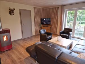 a living room with a couch and a fireplace at Maison Samree met Indoor Wellness in La-Roche-en-Ardenne