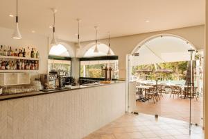 a kitchen with a bar and a table with chairs at Vale d'El Rei Hotel & Villas in Carvoeiro