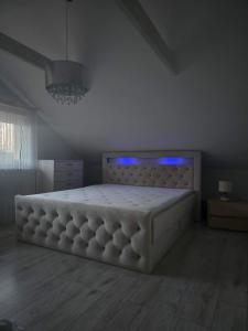 a bedroom with a large white bed with blue lights at D&A Vila - Private Villa with Sauna & Hot Tub in Arciūnai