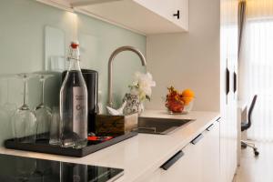 a kitchen counter with a bottle of wine and a sink at Centraltique Veranda Living in Hanoi