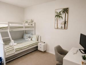 a bedroom with a bunk bed with a desk and a chair at Shell Escape at Ocean Grove in Ocean Grove