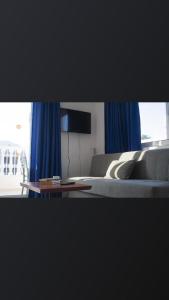 a bedroom with blue curtains and a bed and a table at Atlantis Apart Hotel in Marmaris