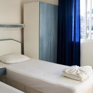 a bedroom with a bed with a blue curtain at Atlantis Apart Hotel in Marmaris