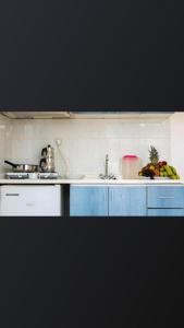 a kitchen with blue cabinets and a sink with bananas at Atlantis Apart Hotel in Marmaris