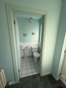 a bathroom with a toilet and a sink at Tullyally House in Castle Cary