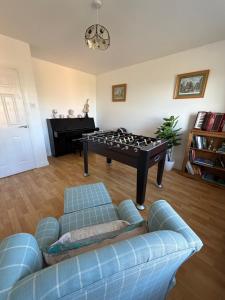 a living room with a couch and a foosball table at Tullyally House in Castle Cary +16 photos