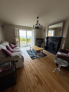 a living room with a couch and a table at Tullyally House in Castle Cary