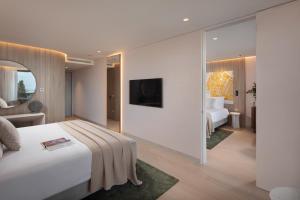 a bedroom with a large white bed and a mirror at Hotel Sumratin in Dubrovnik