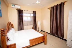 a bedroom with a bed and a window with curtains at Daf House in Zanzibar City