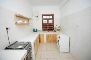 a kitchen with a stove and a washing machine at Daf House in Zanzibar City