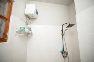 a shower in a bathroom with a white wall at Daf House in Zanzibar City