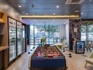 a game room with a pool table in the middle at ibis budget Santiago Providencia in Santiago