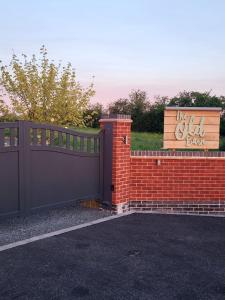 a black fence and a brick wall with a sign at The Old Barn in Hanbury