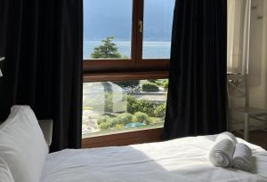 a bedroom with a bed and a large window at Hotel Garda Bellevue in Limone sul Garda +30 photos