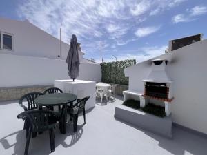 a patio with a table and chairs and a grill at The Vault in Portimão