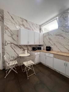 a kitchen with white cabinets and a table and chairs at The Vault in Portimão