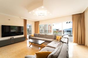 a living room with a couch and a tv at Villa Mevsim in Kaş