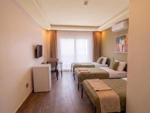 a hotel room with three beds and a couch at Köşk Boutique Hotel - Old Town & City Center in Antalya