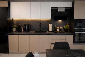 a kitchen with white cabinets and a sink at Blu Riviera Deluxe in Ahtopol