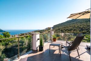 a balcony with an umbrella and a table and chairs at Villa Ekinoks in Kalkan