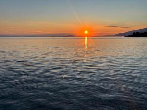 a sunset over a large body of water at Thalia- 2 Bedroom Beachfront Apartment! in Lefokastro