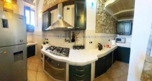 a kitchen with a sink and a stove top oven at La Casetta non è soltanto un alloggio, è storia! in Trentinara