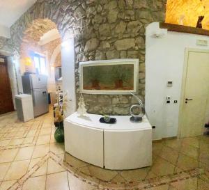 a room with a stone wall with a fish tank at La Casetta non è soltanto un alloggio, è storia! in Trentinara