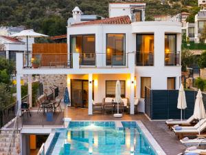 a villa with a swimming pool and a house at Villa Ekinoks in Kalkan