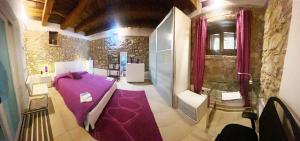 a room with a purple table in a room with a wall at La Casetta non è soltanto un alloggio, è storia! in Trentinara