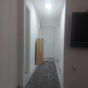 a hallway with a door and a tv on a wall at Apartman Sava in Bosanski Šamac