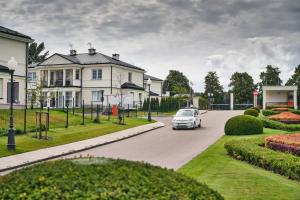 a car driving down a road in front of a house at Tesoro Dolce Vita Apartment in Pogórze