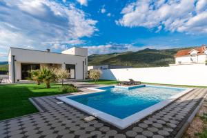 a swimming pool in the backyard of a house at Villa Elysian Blagaj in Blagaj