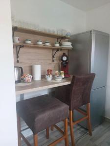 a kitchen with a table and two chairs and a refrigerator at Apartman Sava in Bosanski Šamac