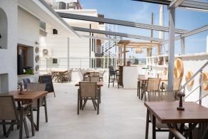 a restaurant with tables and chairs and windows at Siriusmi Hotel in Çeşme
