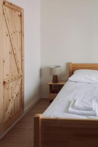 a bedroom with a bed and a wooden door at Apartamenty Wrzosowa 23 z garażem na rowery in Kudowa-Zdrój