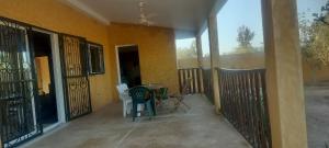 a balcony of a house with a table and chairs at Chez Roseline in Ndangane