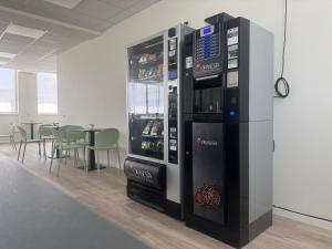 a large vending machine in a room with a table at SPACE101 City Apartment & Studio in Limito di Pioltello